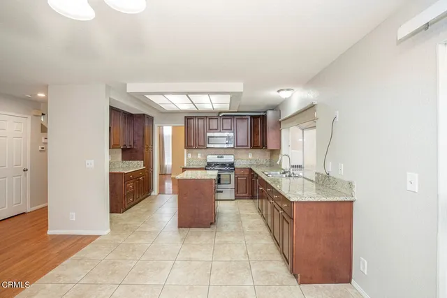 a large kitchen with kitchen island granite countertop a large counter top and stainless steel appliances