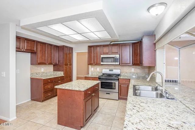 a kitchen with stainless steel appliances granite countertop a stove sink and cabinets
