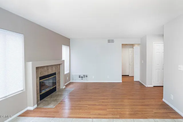 a view of empty room with wooden floor and fireplace