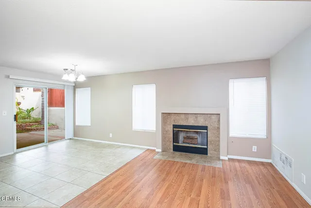 an empty room with windows and fireplace