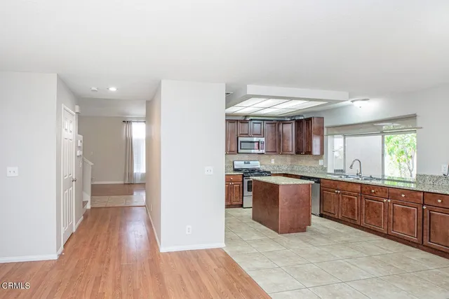 a kitchen with stainless steel appliances granite countertop a sink and wooden floor
