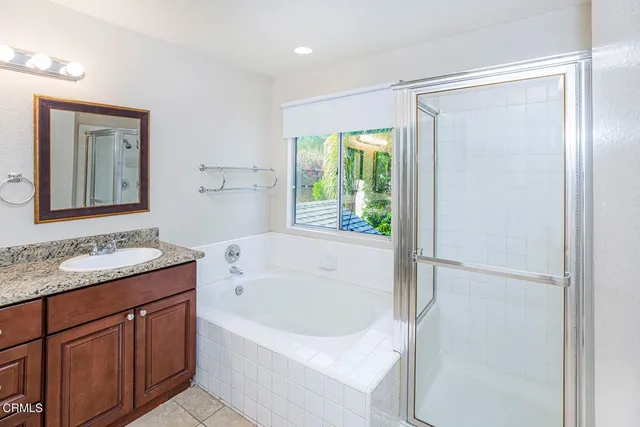 a bathroom with a granite countertop sink and a bathtub