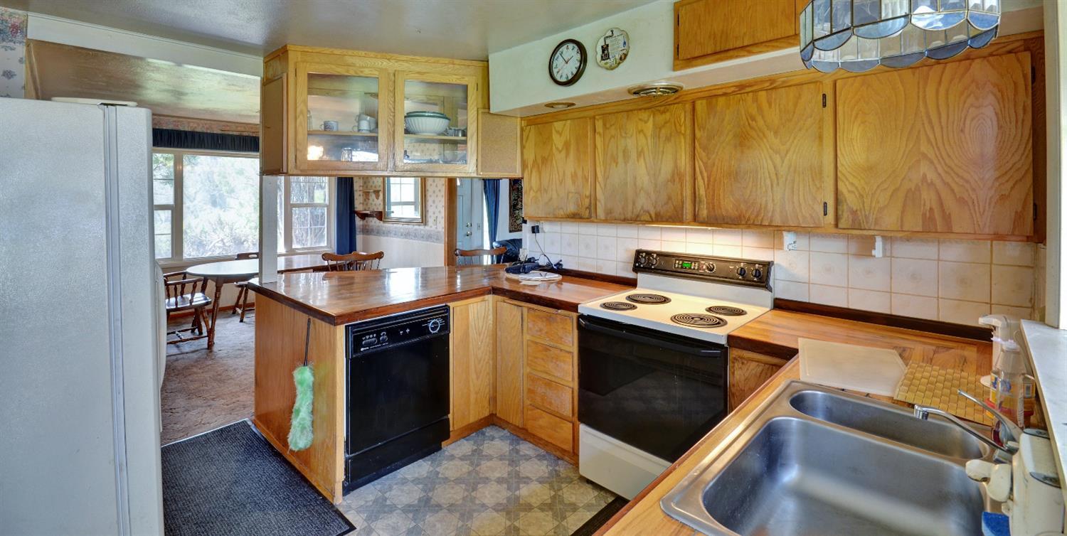 11610 Duggan Road White City, OR 97503 - Photo 13 of 28 a kitchen with stainless steel appliances granite countertop a stove a sink and a microwave