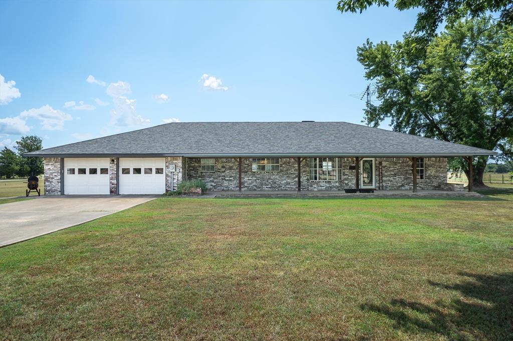 a view of a house with a yard and sitting area