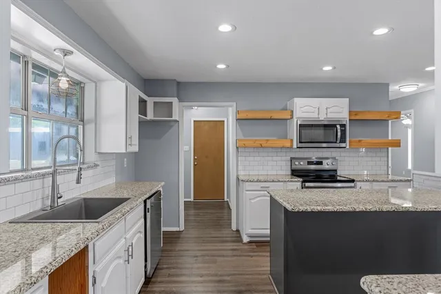 a kitchen with stainless steel appliances granite countertop a sink stove and refrigerator
