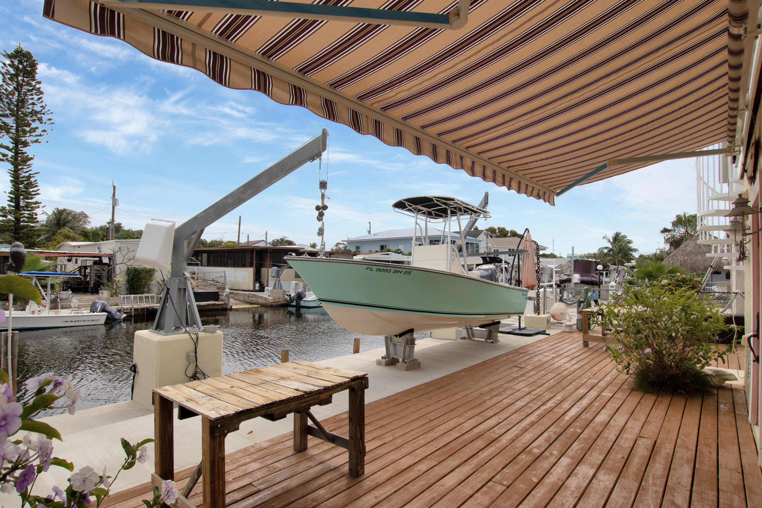 13 Flamingo Road Key Largo, FL 33037 - Photo 51 of 63 a roof deck with table and chairs with wooden floor and plants