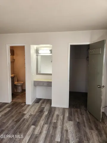 a bathroom with a granite countertop toilet and a sink