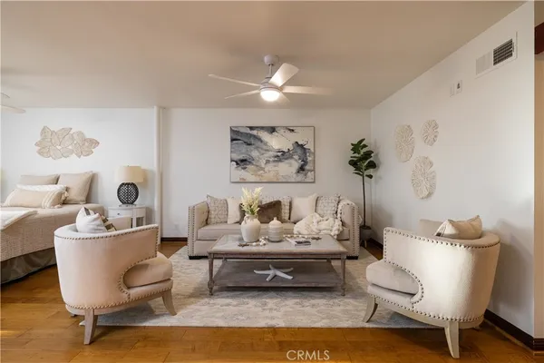 a spacious bedroom with a bed a couch and a chandelier