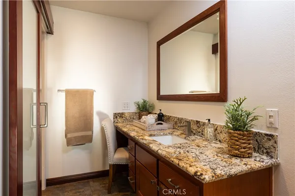 a bathroom with a granite countertop sink a shower and a mirror