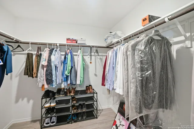 a view of walk in closet with clothes and shoes