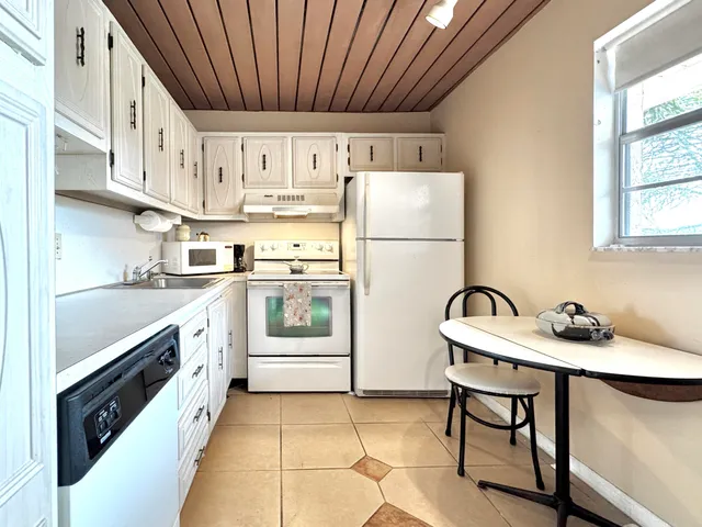 a kitchen with stainless steel appliances a sink a stove a refrigerator cabinets and a window