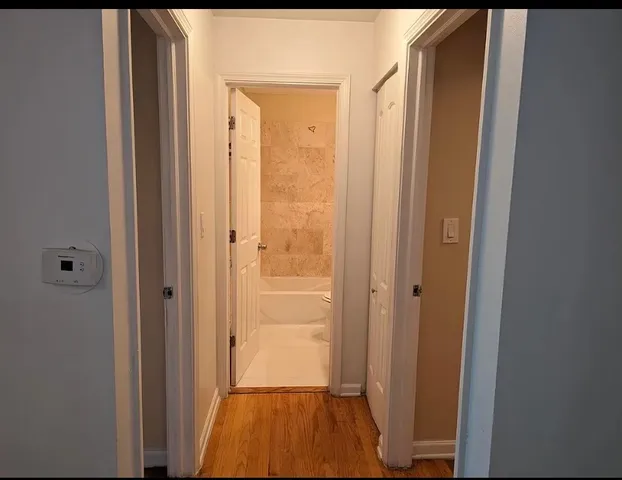 a bathroom with a granite countertop bathtub shower sink vanity and toilet