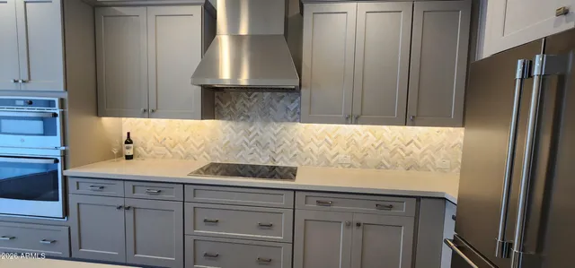 a kitchen with kitchen island wooden floors stainless steel appliances and cabinets