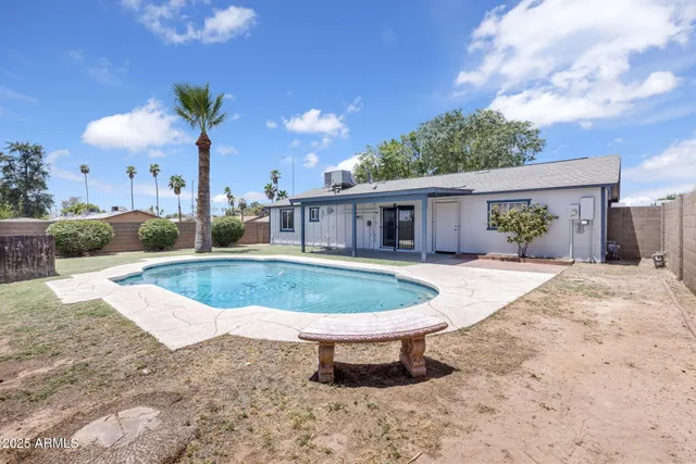 a view of a house with backyard and sitting area