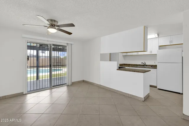 a kitchen with a refrigerator a stove top oven and white cabinets