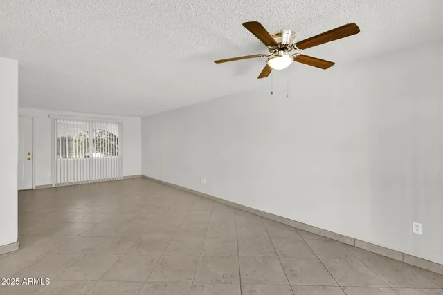 an empty room with closet and ceiling fan