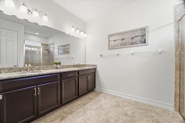a bathroom with a granite countertop sink mirror and vanity