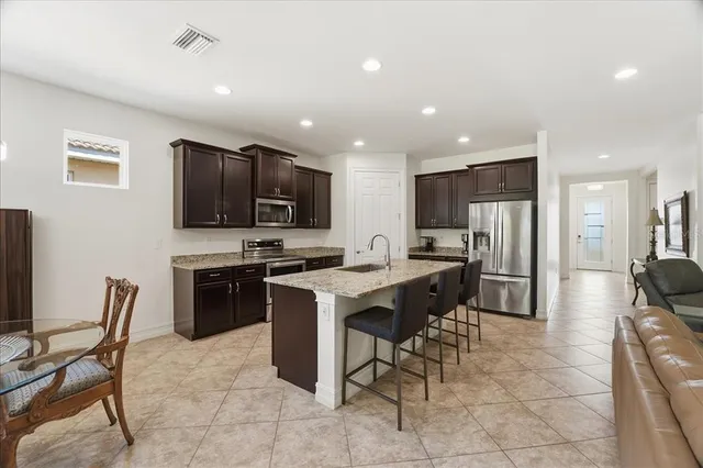 a kitchen with stainless steel appliances granite countertop a refrigerator and a stove top oven