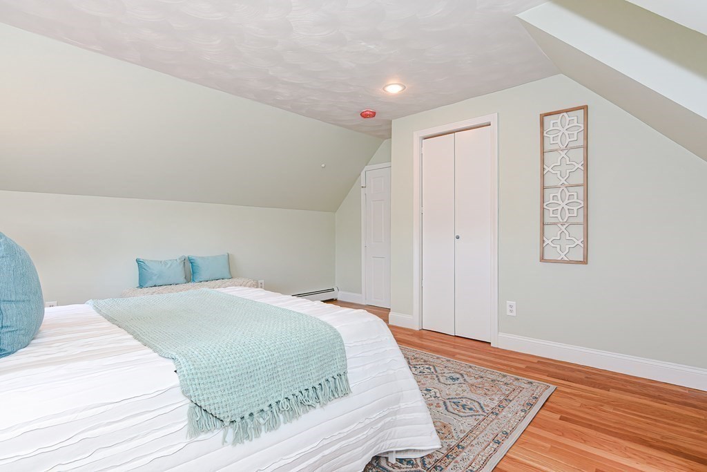 64 Hyde Park Avenue, Unit 3 Boston, MA 02130 - Photo 15 of 27 a bedroom with a bed and wooden floor