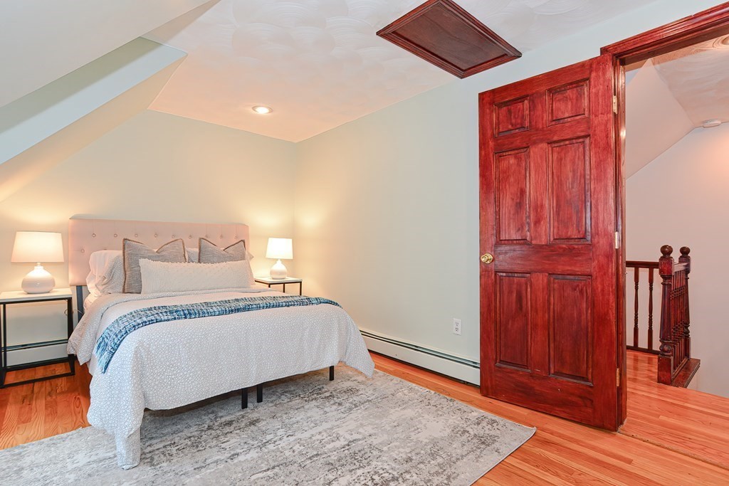 64 Hyde Park Avenue, Unit 3 Boston, MA 02130 - Photo 18 of 27 a bedroom with a bed and wooden floor