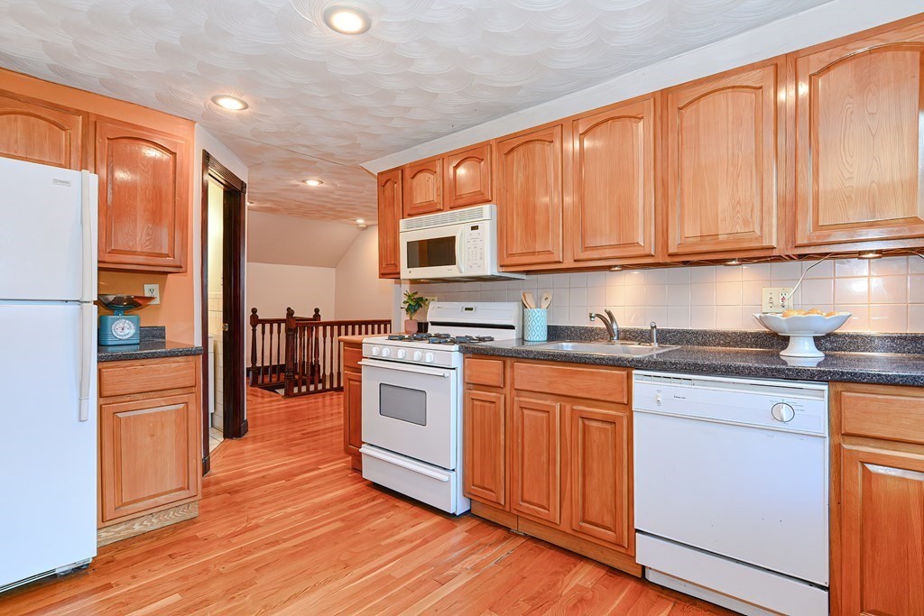 64 Hyde Park Avenue, Unit 3 Boston, MA 02130 - Photo 6 of 27 a kitchen with stainless steel appliances granite countertop a stove top oven a sink and dishwasher with wooden floor