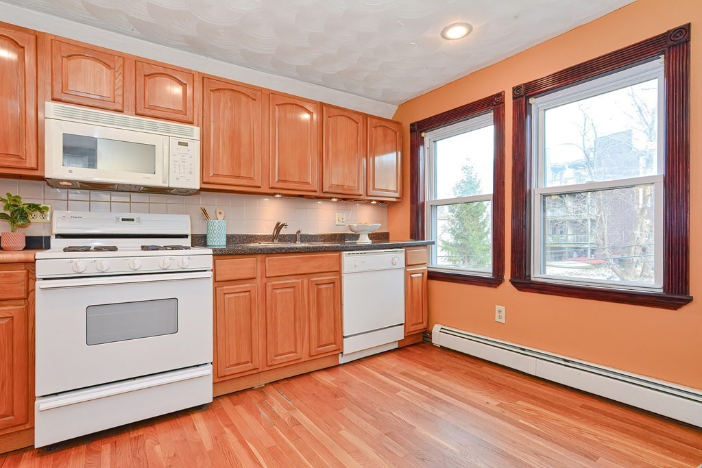 64 Hyde Park Avenue, Unit 3 Boston, MA 02130 - Photo 8 of 27 a kitchen with stainless steel appliances granite countertop a stove a sink and a refrigerator
