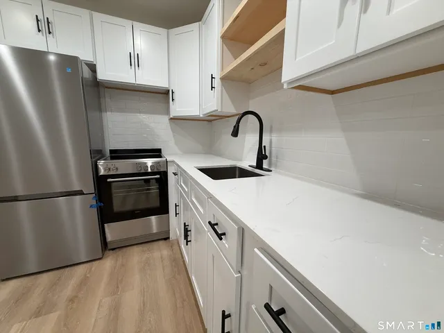 a kitchen with stainless steel appliances a refrigerator sink and cabinets