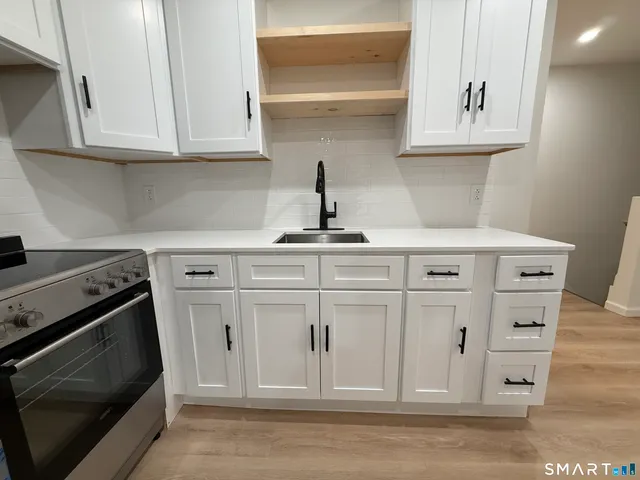 a kitchen with white cabinets and sink