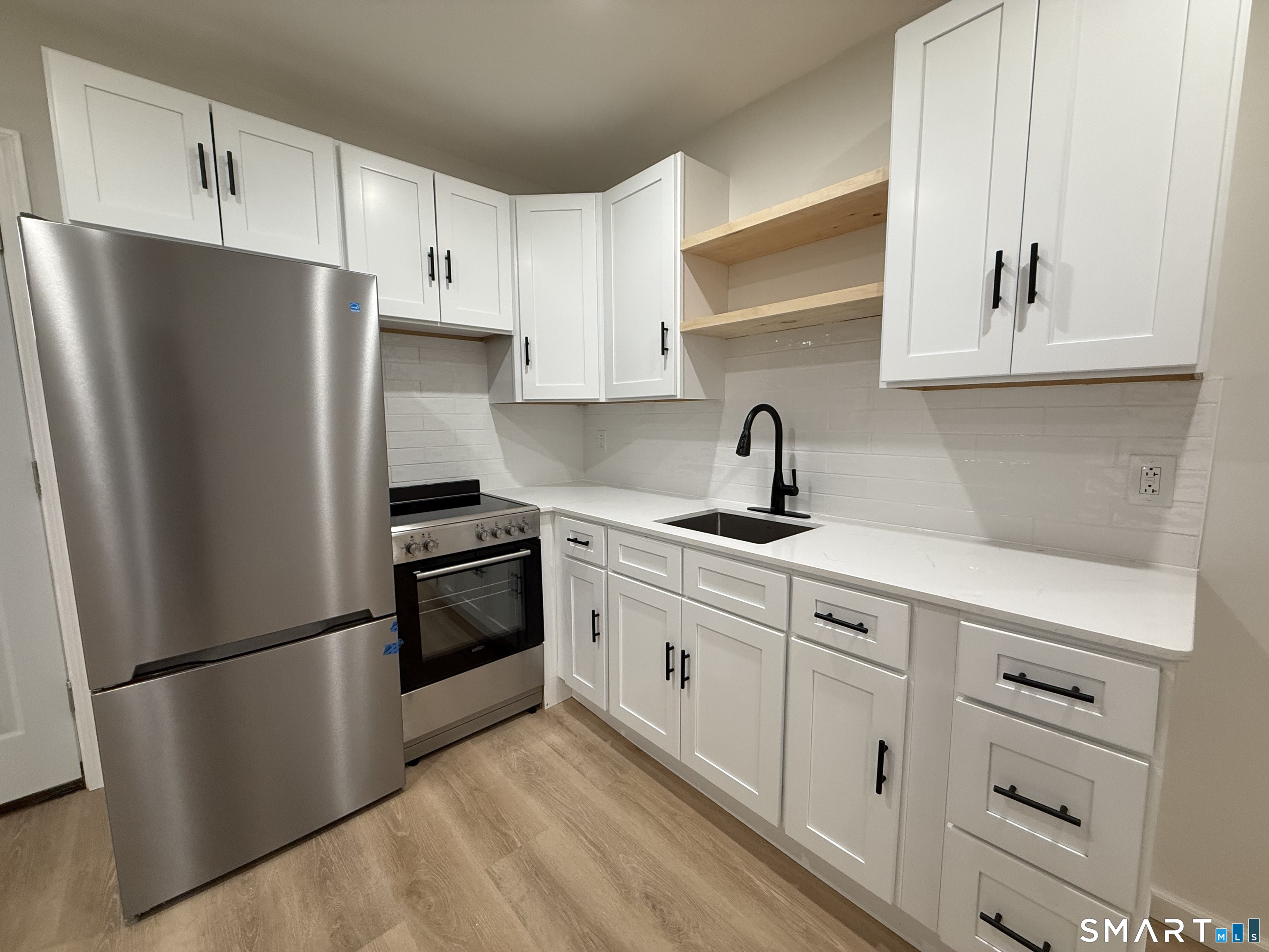 222 Pequonnock Street, Unit 2 Bridgeport, CT 06604 - Photo 6 of 10 a kitchen with stainless steel appliances white cabinets and a refrigerator
