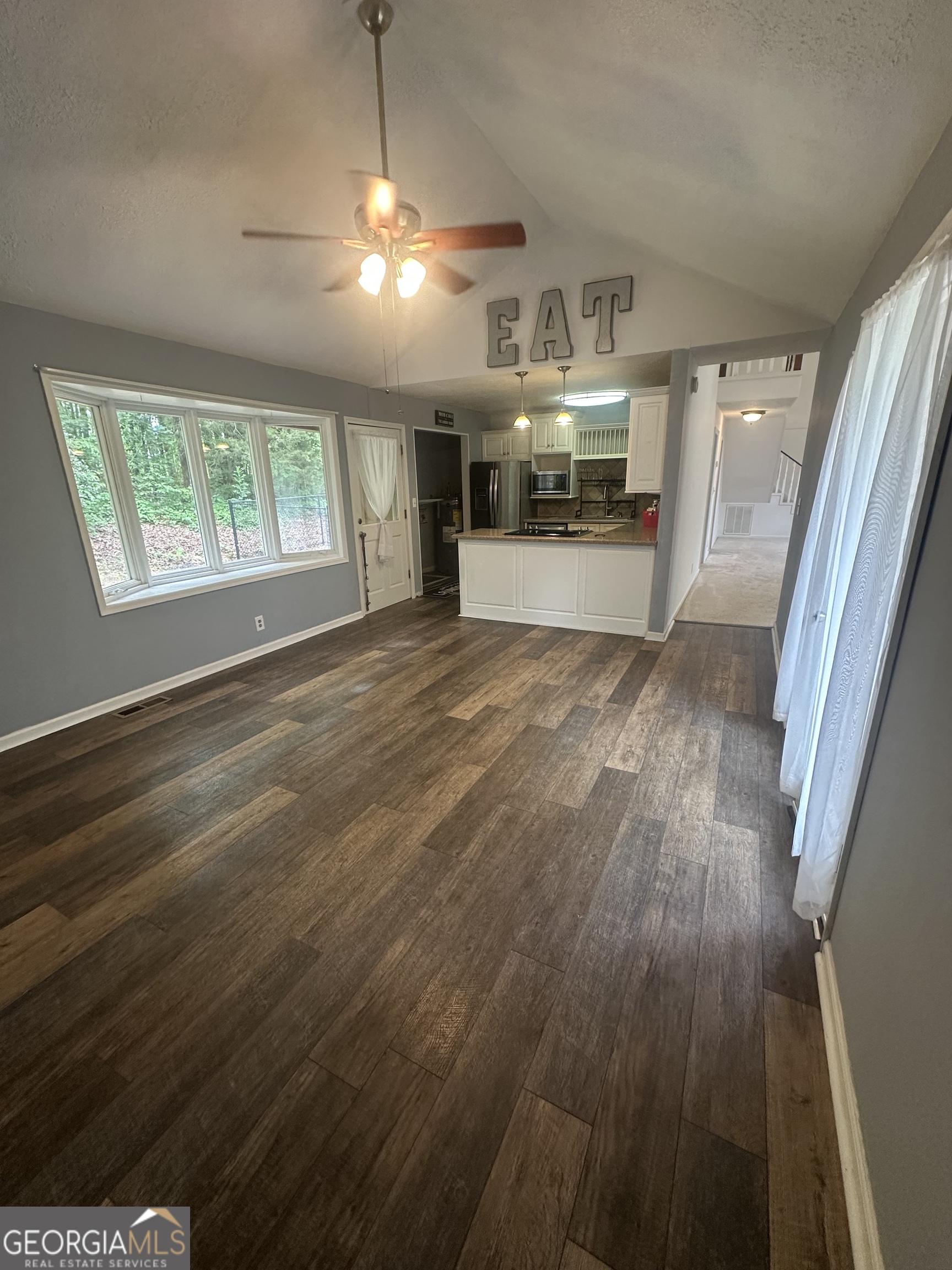7500 Bevis Road Franklin, GA 30217 - Photo 8 of 31 an empty room with wooden floor kitchen view and windows