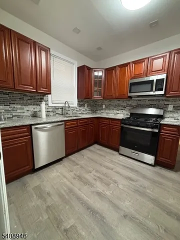 a kitchen with stainless steel appliances granite countertop wooden cabinets a sink and a stove