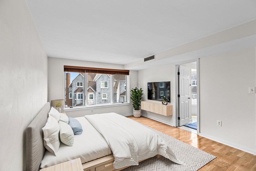 1 Commodore Court, Unit 305 Hull, MA 02045 - Photo 11 of 27 a bedroom with a large bed and a large window