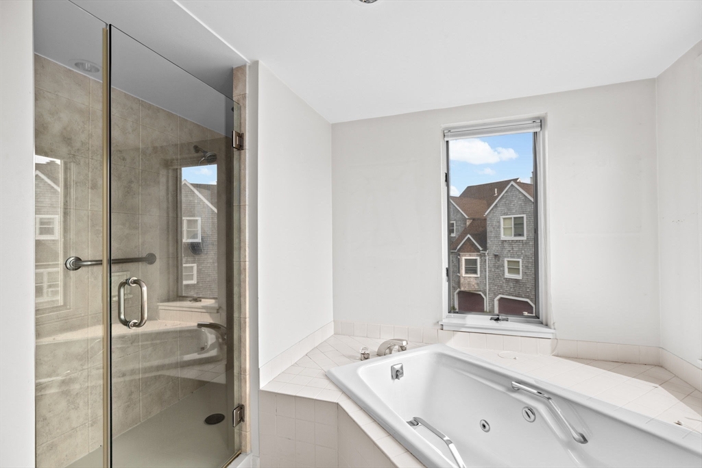 1 Commodore Court, Unit 305 Hull, MA 02045 - Photo 15 of 27 a bathroom with a tub sink and mirror