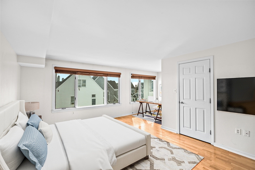 1 Commodore Court, Unit 305 Hull, MA 02045 - Photo 16 of 27 a spacious bedroom with a bed and a flat screen tv