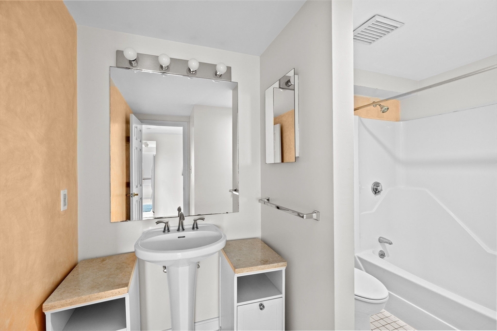 1 Commodore Court, Unit 305 Hull, MA 02045 - Photo 18 of 27 a bathroom with a sink a toilet and shower