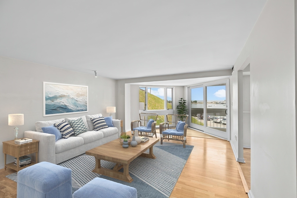 1 Commodore Court, Unit 305 Hull, MA 02045 - Photo 3 of 27 a living room with furniture and a large window