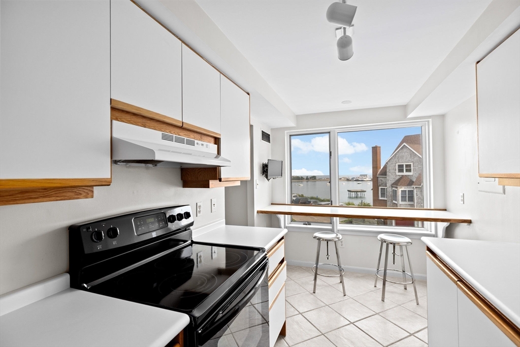 1 Commodore Court, Unit 305 Hull, MA 02045 - Photo 7 of 27 a kitchen with a stove a sink and a refrigerator