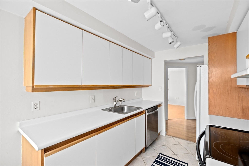 1 Commodore Court, Unit 305 Hull, MA 02045 - Photo 8 of 27 a kitchen with a sink and a refrigerator