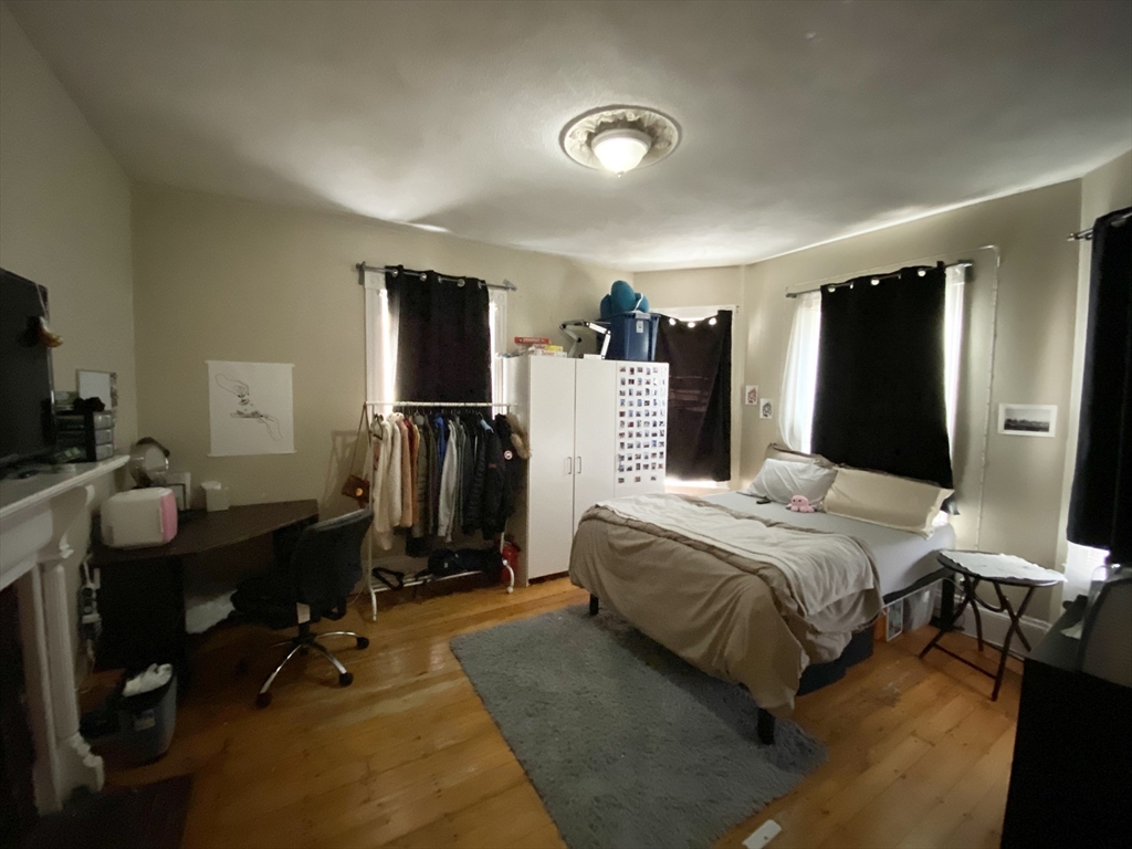 72 Calumet Street, Unit 1 Boston, MA 02120 - Photo 6 of 8 a bedroom with a bed gym equipment and a large window