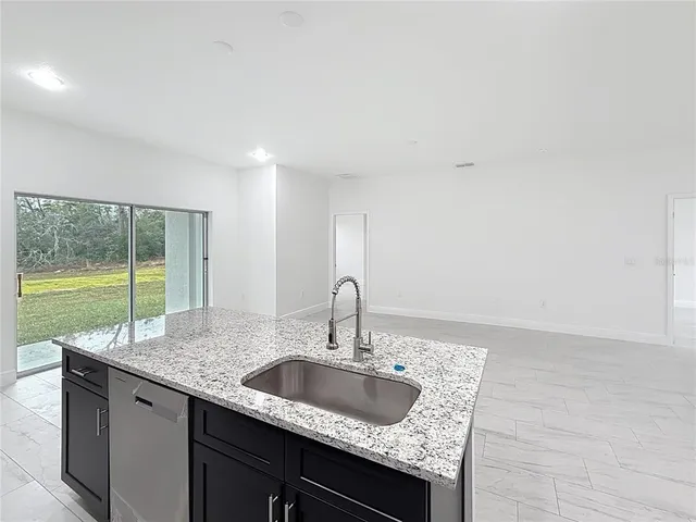 a kitchen with granite countertop a sink and a wooden floor
