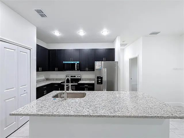 a kitchen with a refrigerator sink and stove