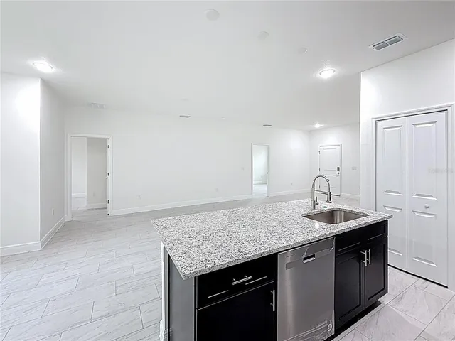 a kitchen with granite countertop kitchen island a sink and a stove