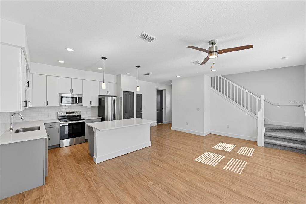1898 Zac Street, Unit RADIANCE Kissimmee, FL 34743 - Photo 4 of 20 a view of kitchen with stainless steel appliances refrigerator stove microwave and cabinets