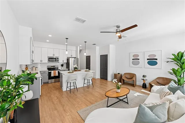 a living room with furniture kitchen view and a potted plant