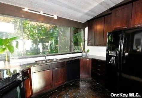 a kitchen with stainless steel appliances granite countertop a sink a stove and a refrigerator