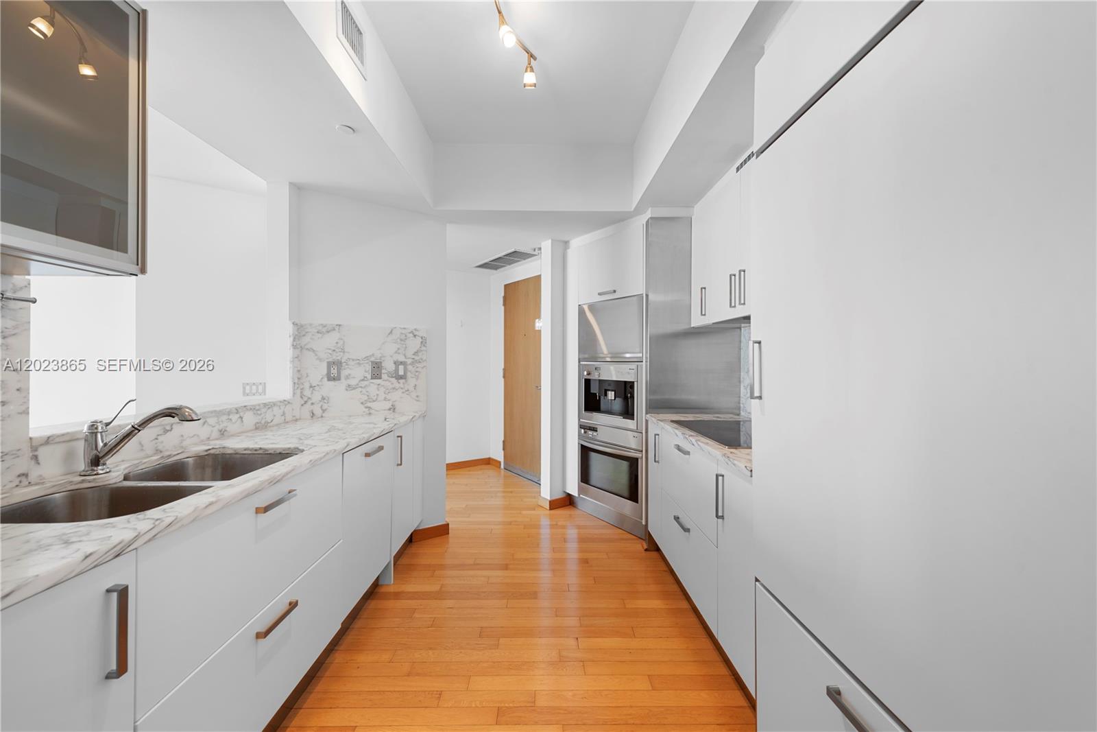 450 Alton Road, Unit 3206 Miami Beach, FL 33139 - Photo 7 of 25 a large kitchen with a sink and dishwasher a stove top oven