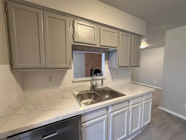 a kitchen with a sink and wooden floor