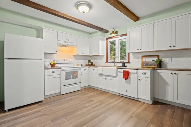 a kitchen with white cabinets and white appliances