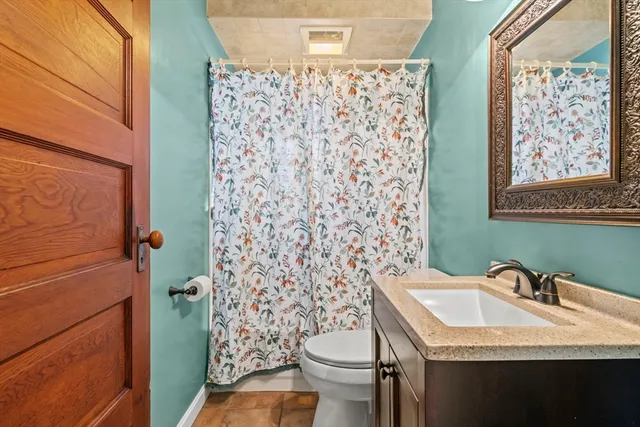 a bathroom with a granite countertop sink toilet and shower