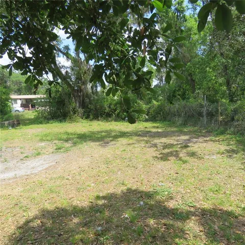 a view of a field with a trees in the background